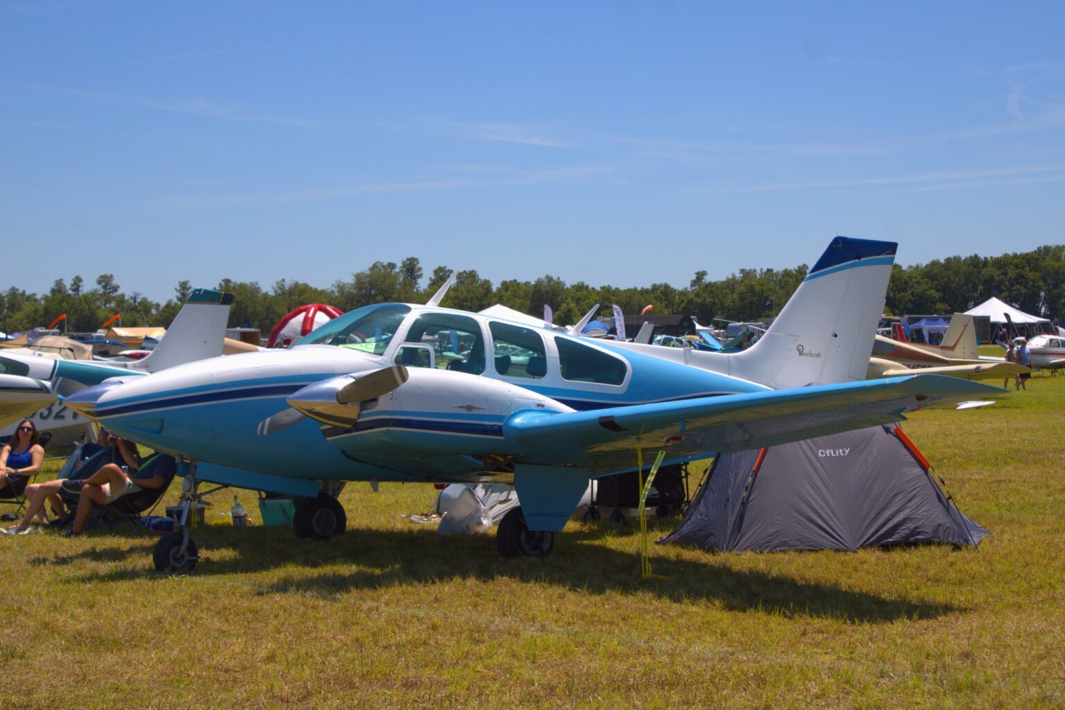 Blue and white Beechcraft 95-55 Baron N938Q parked on grass at an airfield