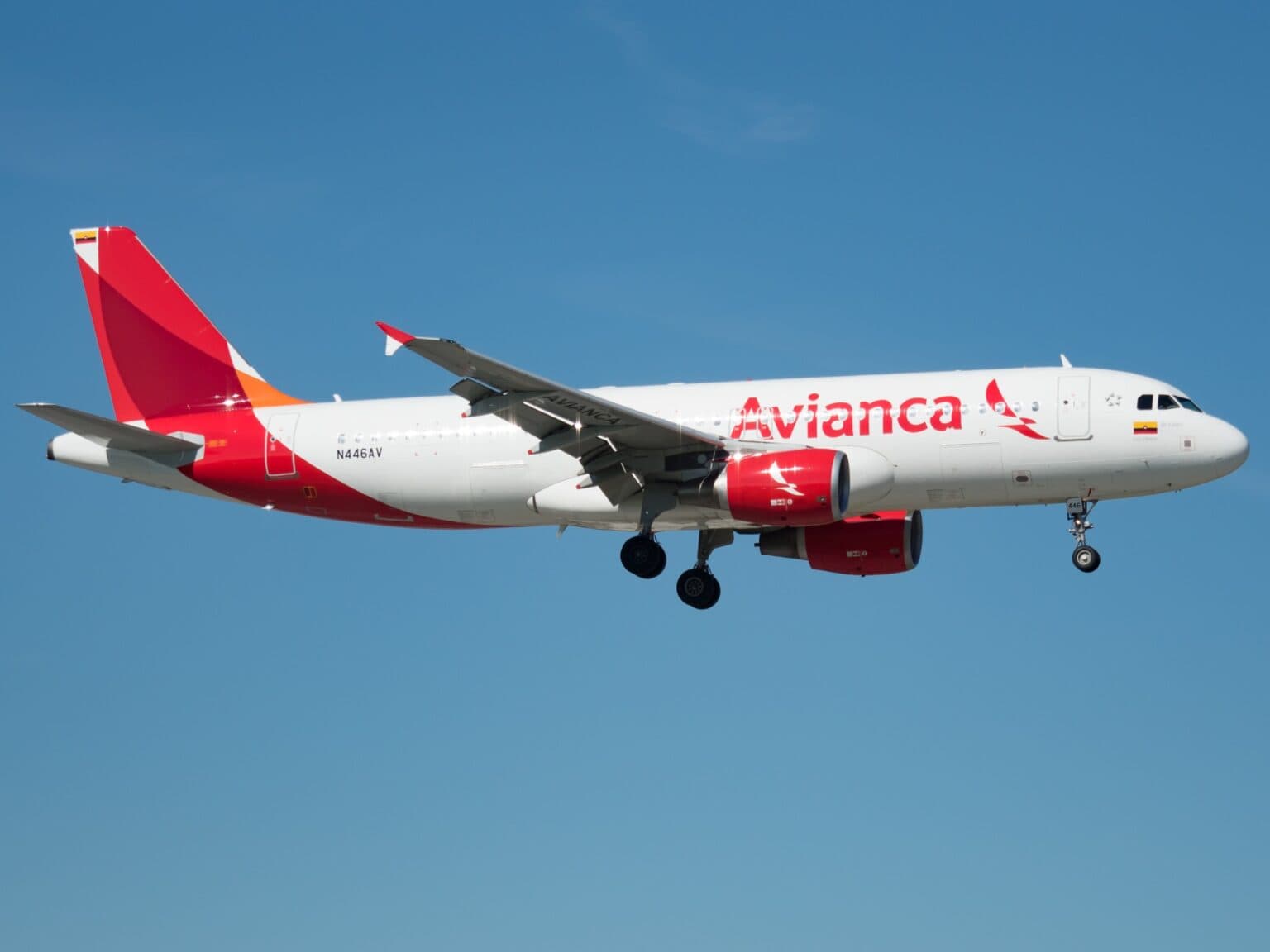 Avianca Airbus A320 N446AV on approach with its landing gear down against a clear blue sky