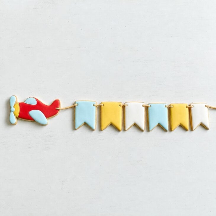 One letter per cookie spells a name behind a towing plane.