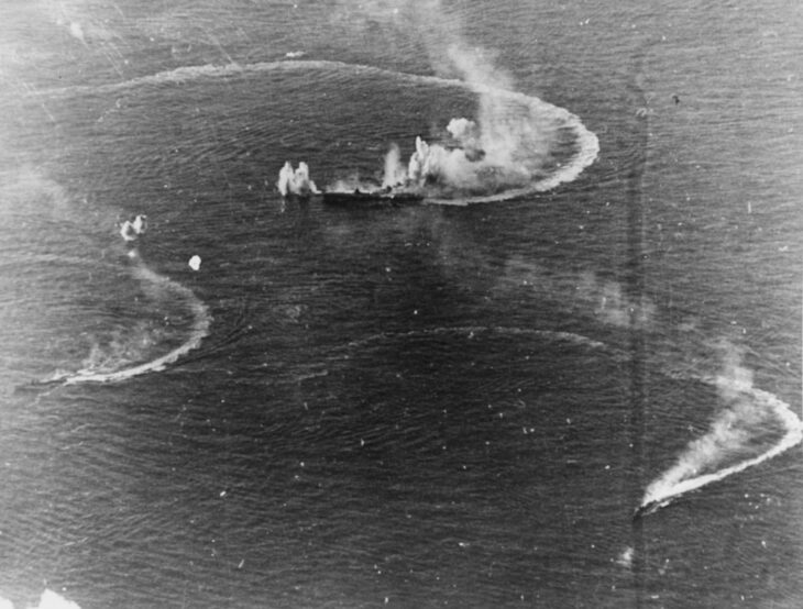 Aerial view of the Japanese carrier Zuikaku turning with bomb splashes and two destroyers wheeling around her on June 20, 1944