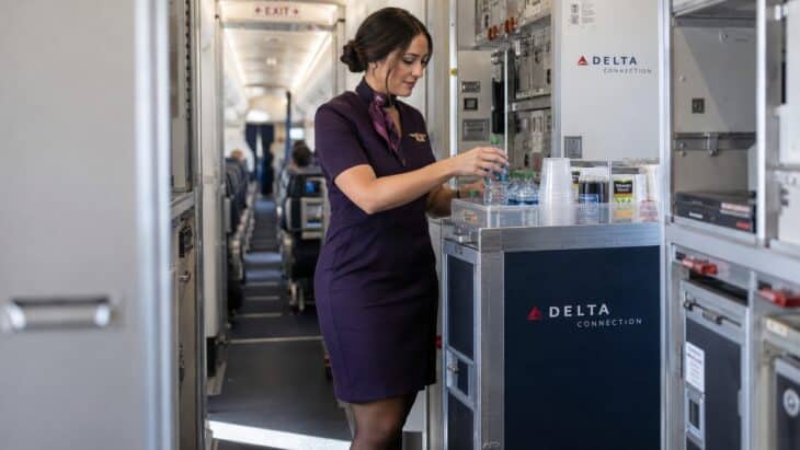 An Endeavor flight attendant restocking a beverage cart in the galley