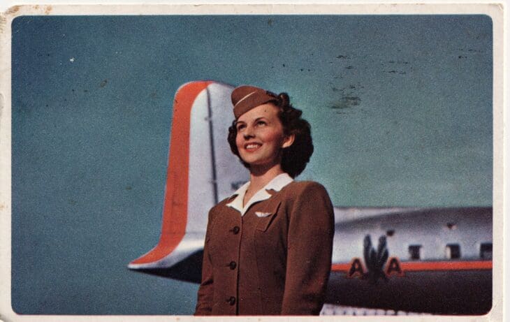 1949 portrait of an American Airlines stewardess in uniform in front of an aircraft tail