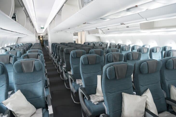 Cathay Pacific Airbus A350 economy cabin with rows of blue-grey seats in a 3-3-3 layout