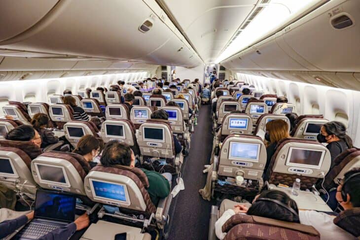Korean Air Boeing 777-300ER economy cabin in flight, seen from behind the seats