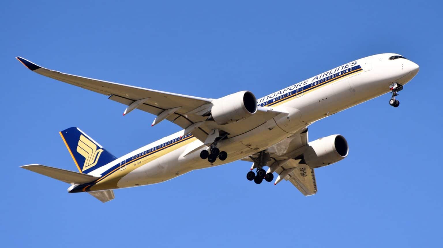 Singapore Airlines Airbus A350-900 9V-SHP banking in flight against a blue sky