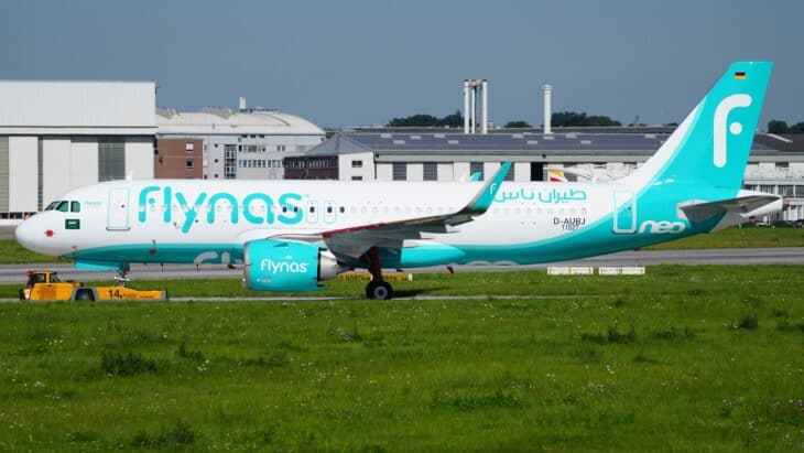 flynas Airbus A320-251N neo in teal and white livery on a grass-edged taxiway