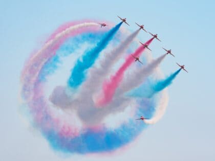 Red Arrows Hawks peeling out of a loop of red, white and blue smoke