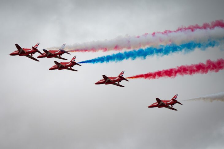 Red Arrows Hawks trailing red, white and blue smoke in a close formation