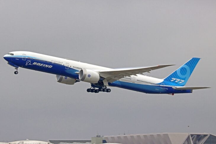 Boeing 777-9 test aircraft N779XW in Boeing house livery climbing out with folding wingtips extended