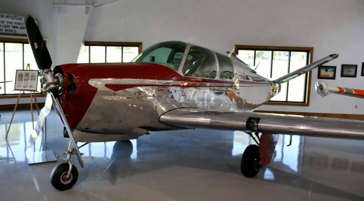 Polished 1947 Beechcraft Model 35 Bonanza N80409 with its V-tail, displayed in a museum hangar
