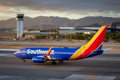 Southwest Airlines Boeing 737 taxiing at Hollywood Burbank Airport at dusk with the control tower and mountains behind