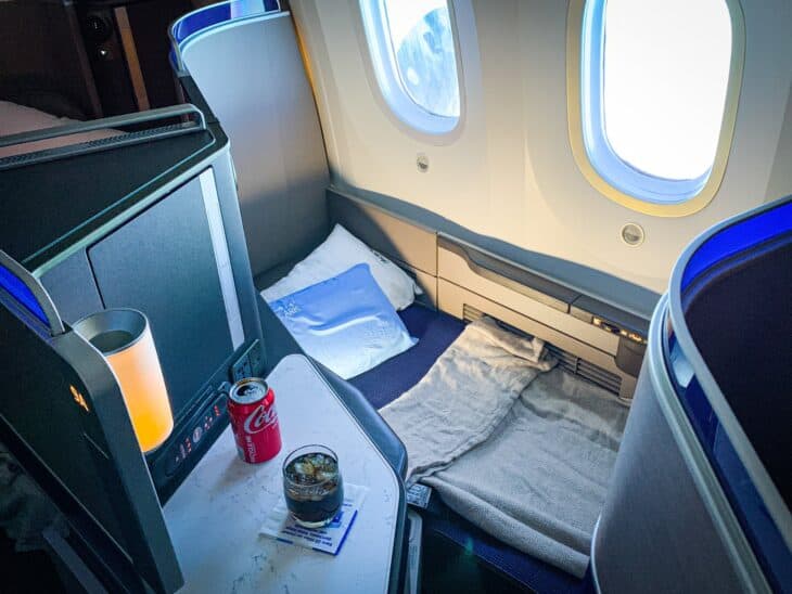 United Polaris lie-flat seat on a Boeing 787 made up as a bed with pillow and blanket