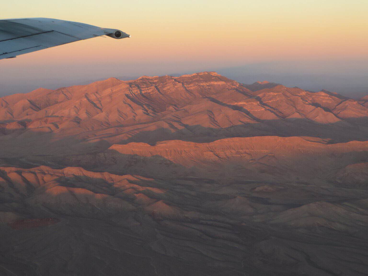 Potosi Mountain in the Spring Mountains of Nevada, its ridges lit red by low evening light, seen from the air