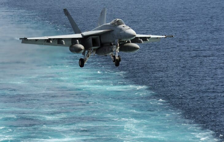 An F/A-18E Super Hornet from the Kestrels of Strike Fighter Squadron 137 approaching a carrier flight deck in the Arabian Sea