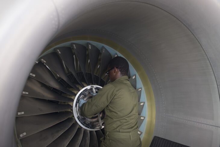 A technician reaches into the fan of a CFM56-7B engine on a US Navy P-8A Poseidon during a maintenance inspection