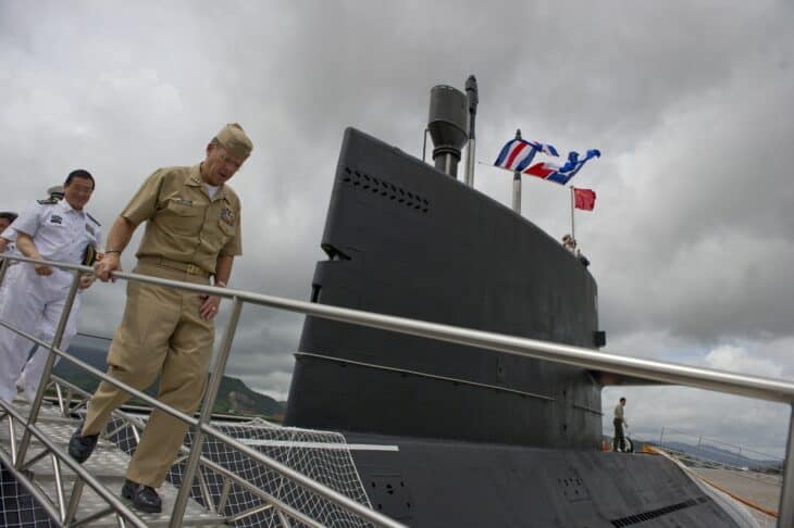 Chinese Type 039 Yuan-class submarine alongside a pier with its sail and flags