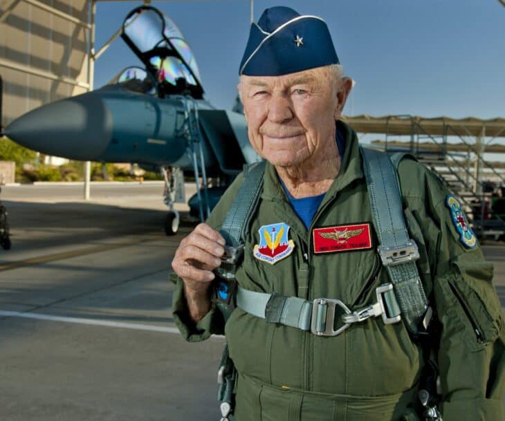 Chuck Yeager in a flight suit beside a US Air Force F-15D Eagle