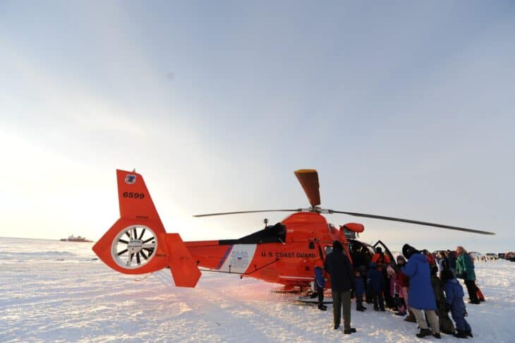 Coast Guard MH-65 Dolphin on the ice at Nome, Alaska, with local residents gathered around it