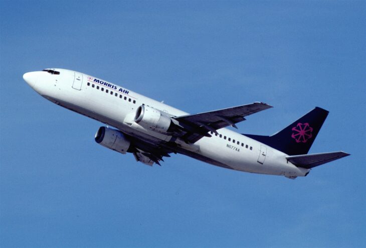 Morris Air Boeing 737-300 climbing out against a blue sky