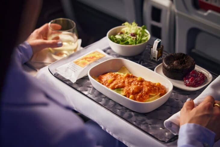 Premium Select meal tray with tortellini, salad, dessert and a glass of white wine on a Delta widebody