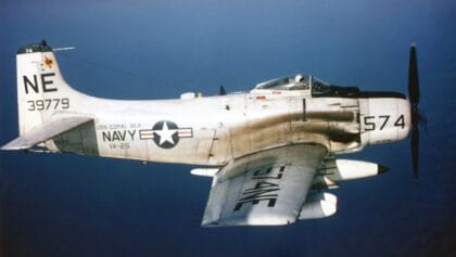 Douglas A-1H Skyraider of VA-25 from USS Coral Sea banking in flight over blue water