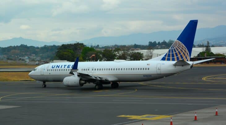 A United Airlines Boeing 737-800 on the ramp at San José's Juan Santamaría airport with mountains behind