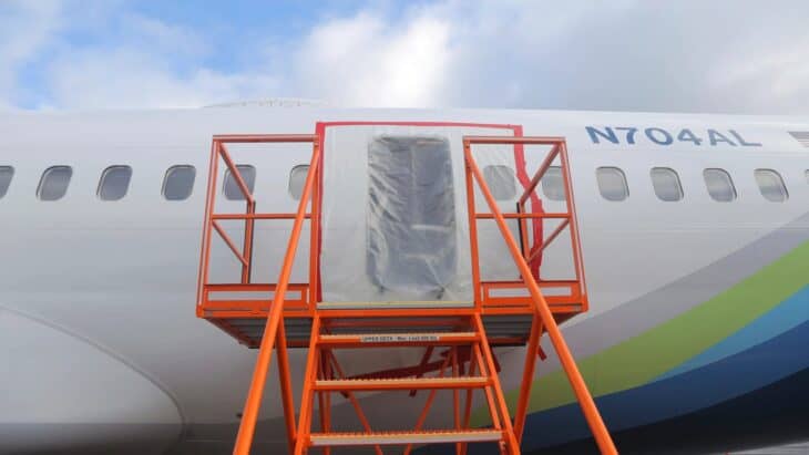 Alaska Airlines Boeing 737 MAX 9 N704AL with the fuselage door plug opening covered and surrounded by an access stand after the January 2024 blowout