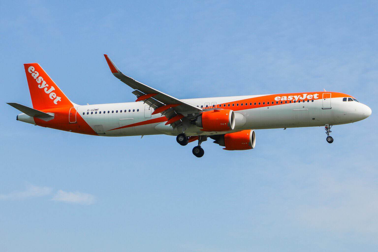 easyJet Airbus A321neo in orange livery on approach against a blue sky
