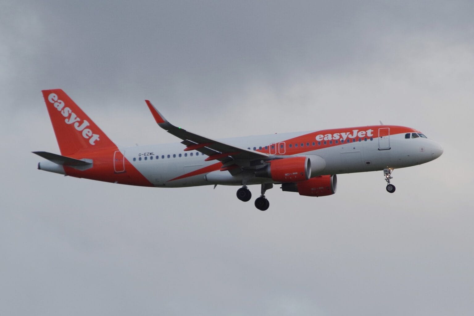 easyJet Airbus A320 G-EZWL in white and orange livery on approach with landing gear down under a grey sky