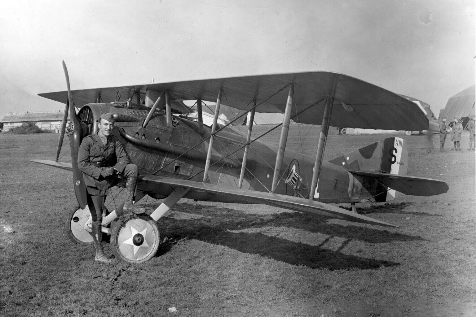 Captain Eddie Rickenbacker sitting on the wing root of a SPAD XIII of the 94th Aero Squadron