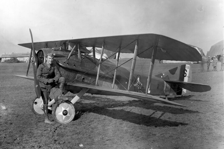 Captain Eddie Rickenbacker sitting on the wing root of a SPAD XIII of the 94th Aero Squadron