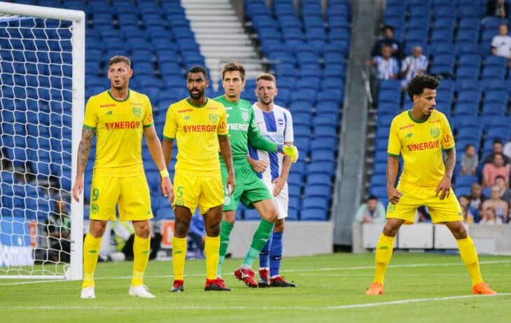Nantes players in yellow, including the No. 9 on the left, line up near a free kick against Brighton in August 2018