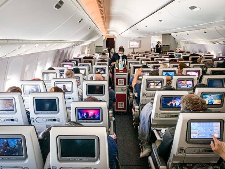 Qatar Airways Boeing 777-300ER economy cabin in a 3-4-3 layout with seatback screens