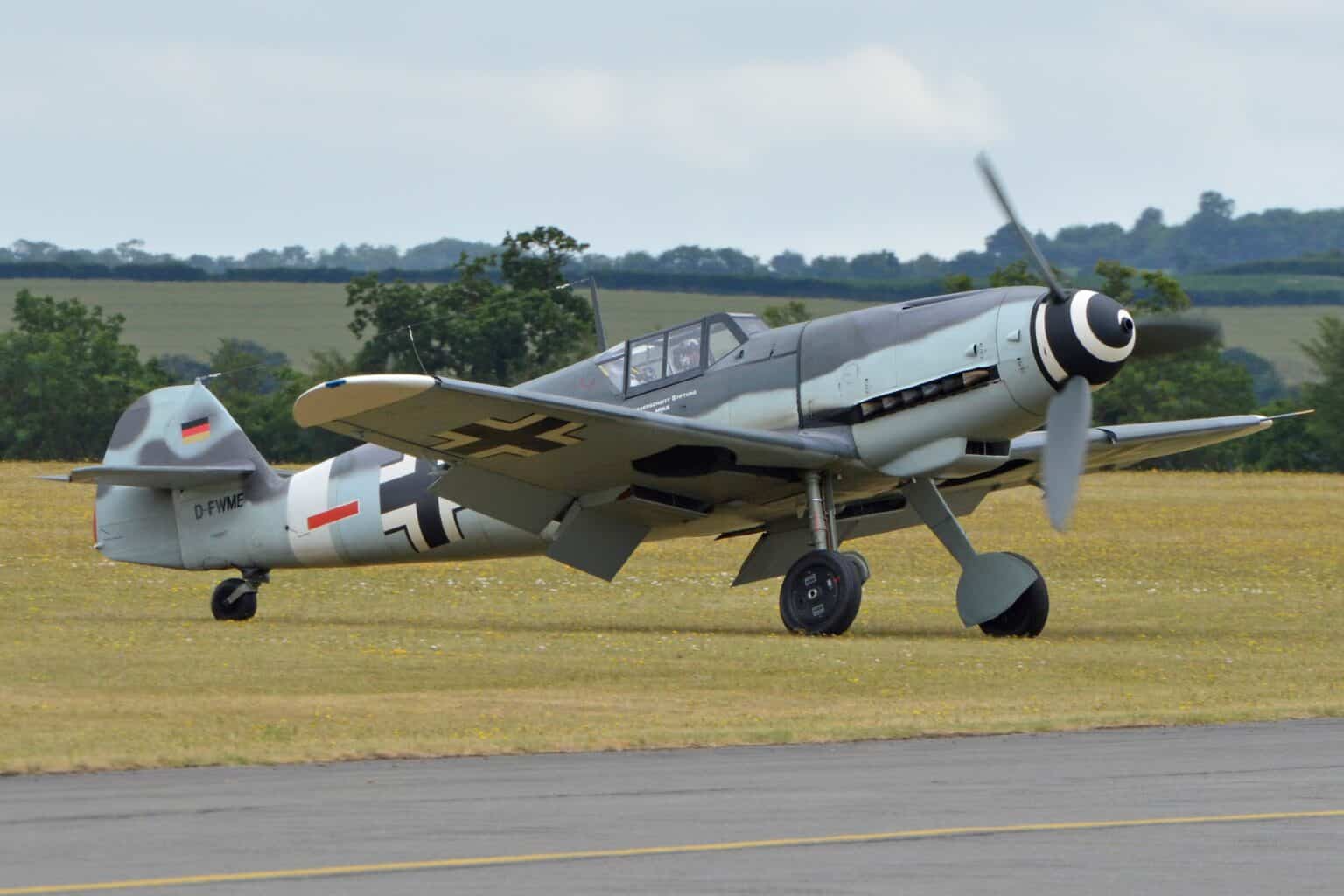 Spanish-built Hispano Buchon painted as a Messerschmitt Bf 109G-4 'Red 7' taxiing across grass at an airshow
