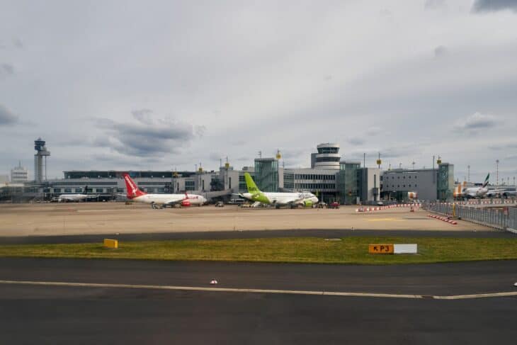 Düsseldorf Airport terminal and control tower seen across the apron, with aircraft parked at the gates