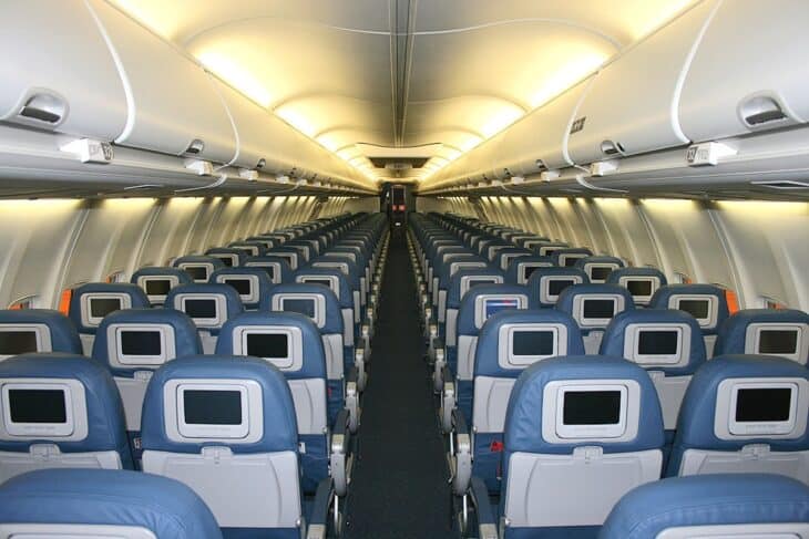 Cabin of a Delta Air Lines Boeing 737-800 looking down the aisle, with overhead panels above the seat rows