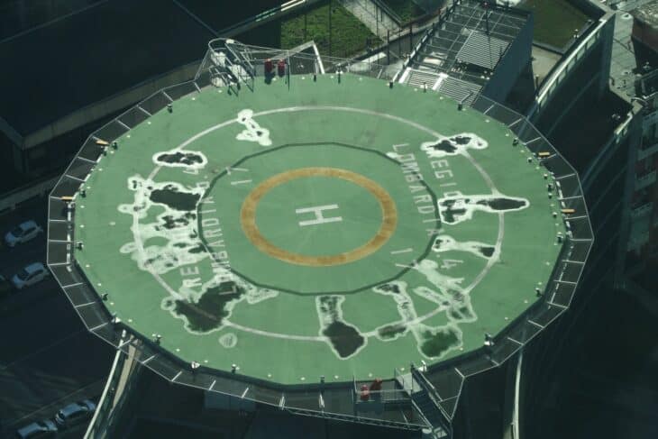 Rooftop helipad with a painted H marking above a city street in Milan