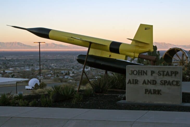 Lockheed X-7 ramjet test vehicle on a pylon display with a mountain backdrop at sunset