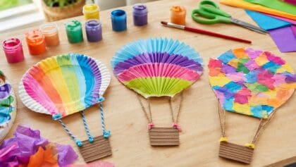 Colorful hot air balloon crafts made from paper plates, cupcake liners and tissue paper on a craft table