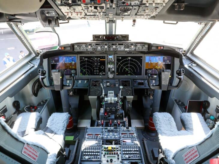 Flight deck of a Boeing 737 MAX with both pilot seats empty and the overhead panel visible