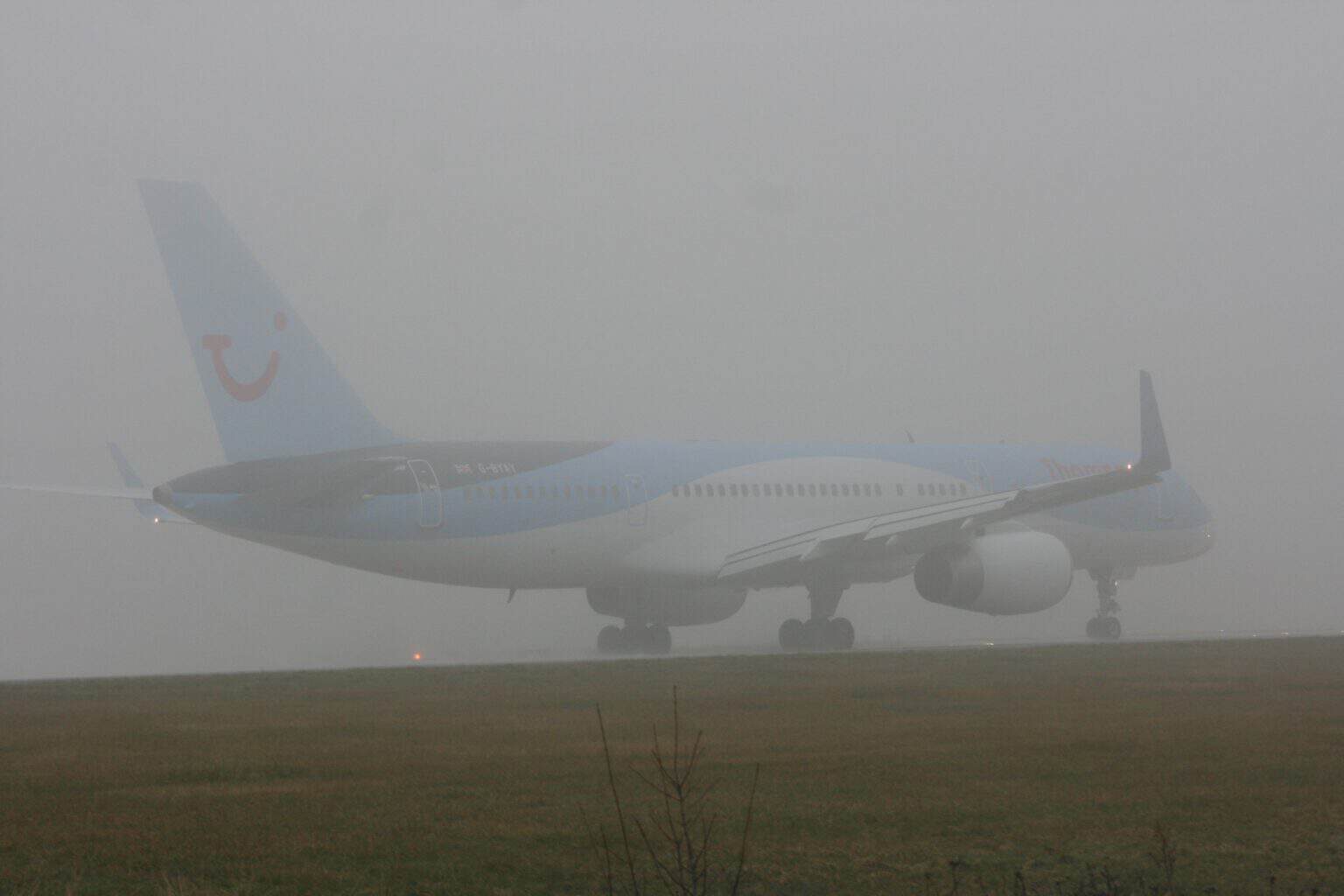 Thomson Airways Boeing 757 G-BYAY on the runway at Leeds Bradford, half hidden in thick fog