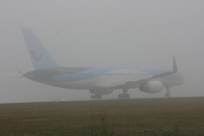 Thomson Airways Boeing 757 G-BYAY on the runway at Leeds Bradford, half hidden in thick fog