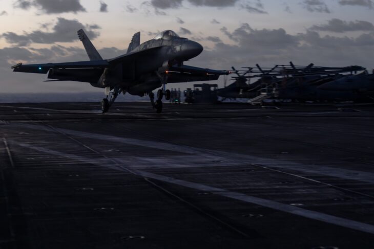 An F/A-18E Super Hornet of Carrier Air Wing 8 on the flight deck of USS Gerald R. Ford at dusk