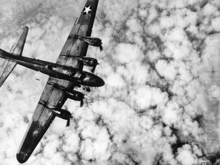 Boeing B-17F Flying Fortress seen from above banking over clouds during a wartime mission