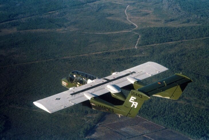 Marine Corps OV-10A Bronco of VMO-1 banking over forest in 1982