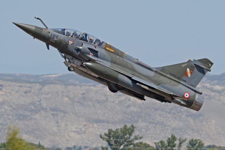 French Air Force Mirage 2000D in green and grey camouflage lifting off with its gear retracting