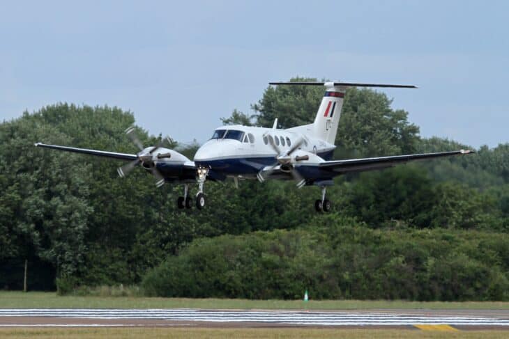 Beechcraft King Air B200 with gear down, flaring over the runway threshold to land