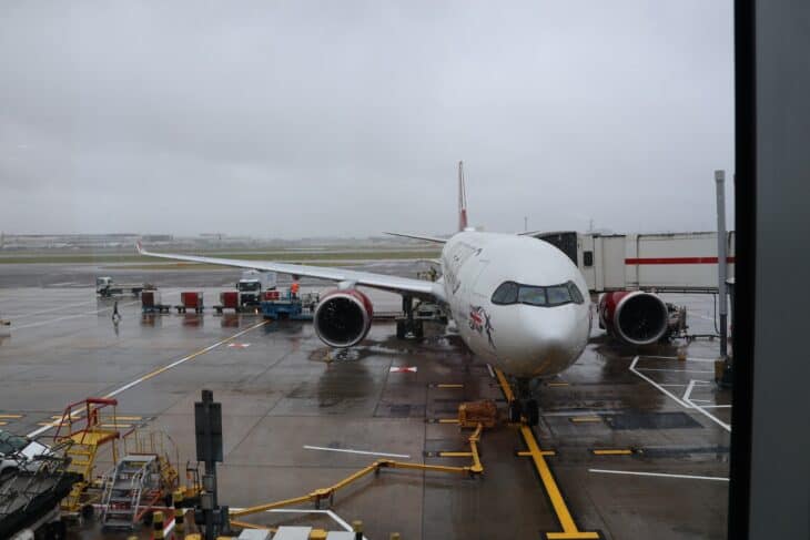 Virgin Atlantic widebody parked at a Terminal 3 stand at Heathrow in the rain