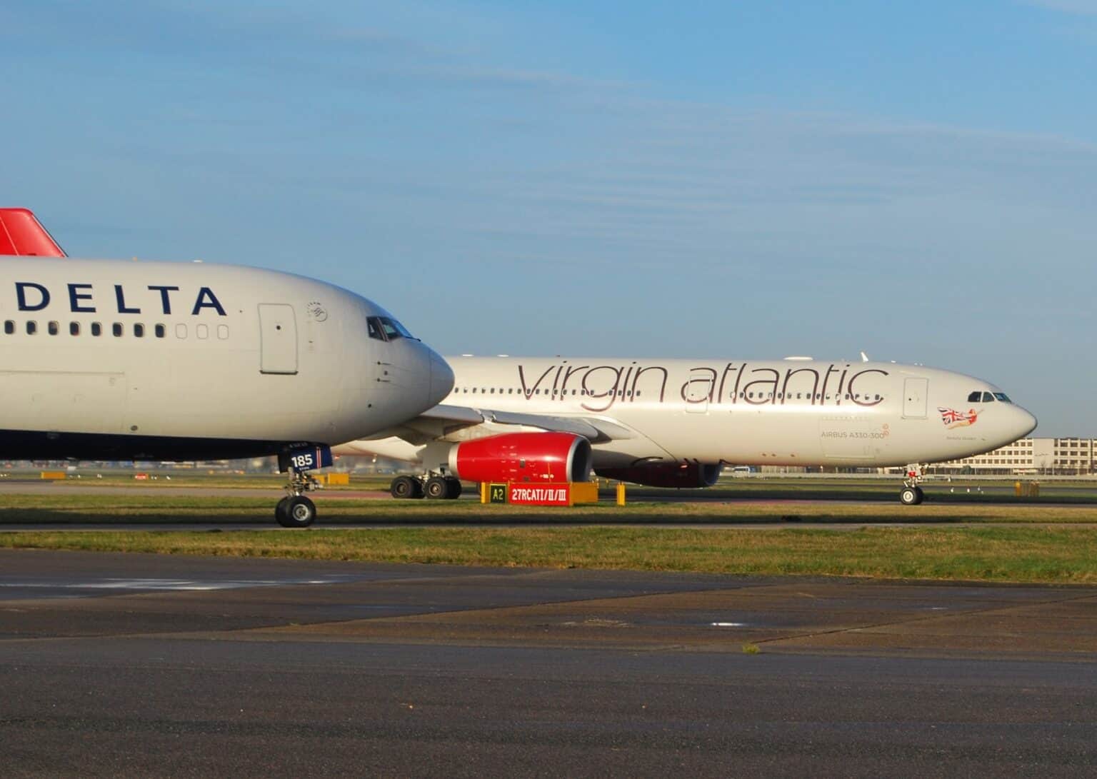 Delta Air Lines jet taxiing past a Virgin Atlantic aircraft at London Heathrow