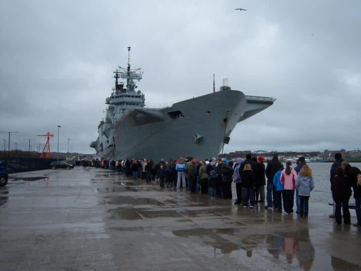 Visitors queuing on the quayside beside the bow of the Invincible-class carrier HMS Ark Royal (R07)